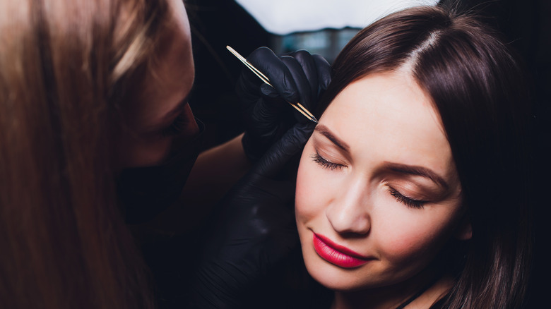 makeup artist applying eyebrow makeup