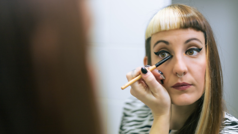 Girl applying cat eyeliner