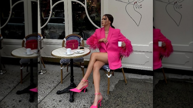 woman sitting at table with bright pink outfit