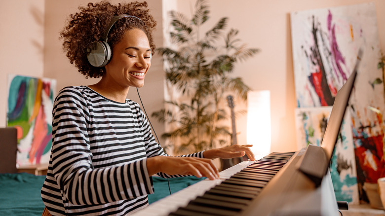 Woman grins while playing piano