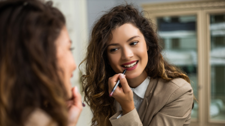 Woman applying lip liner 