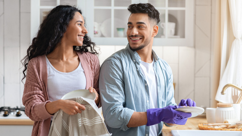 couple smiling and doing dishes together