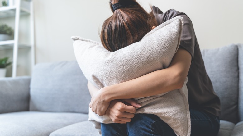 unhappy woman burying head in pillow