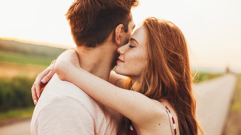 young couple hugging outside