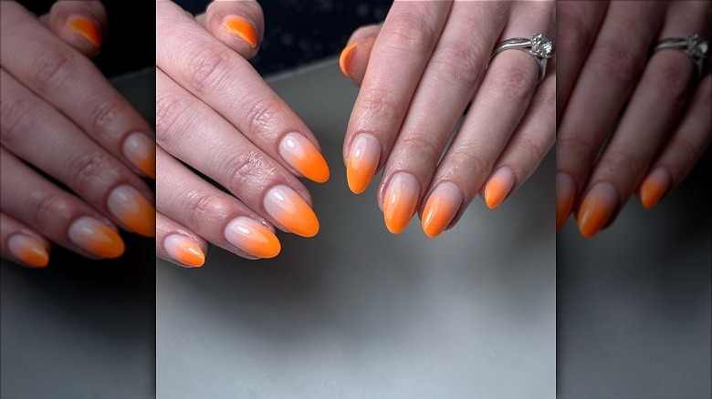 hands with orange french fade nails