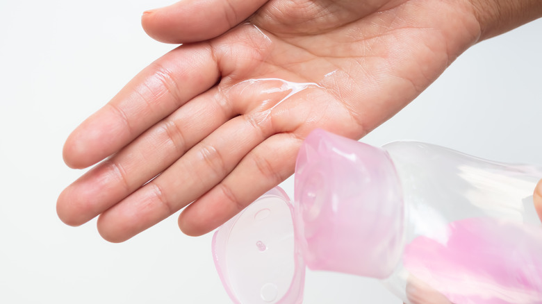 Person pouring baby oil on hand