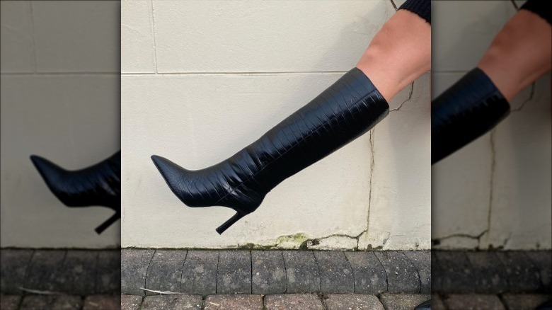 person wearing black leather boot