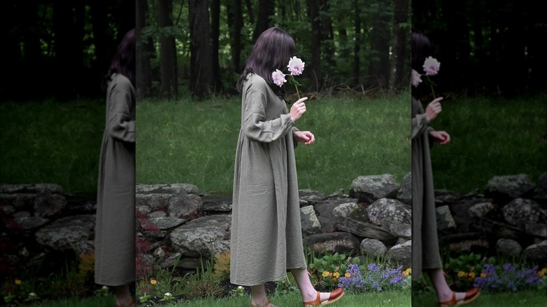 Girl wearing green gown, holding flowers