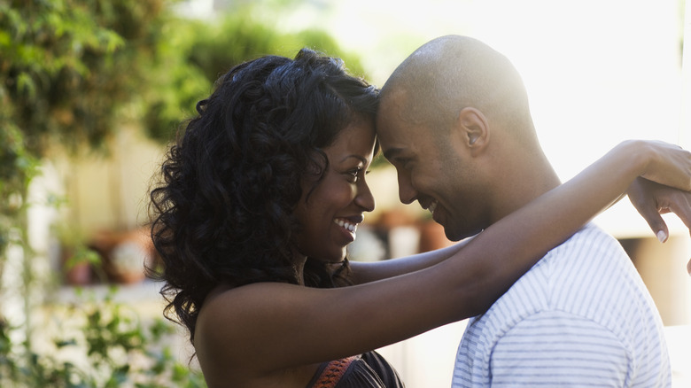 woman putting arms around man