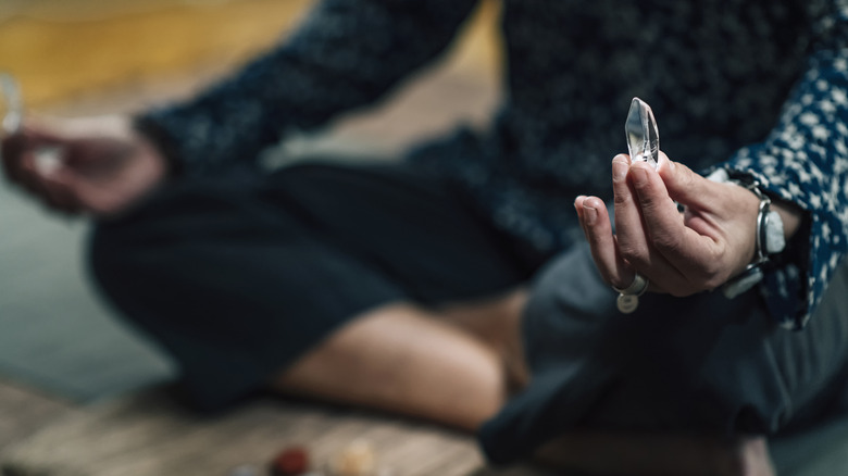 Woman meditating with quartz