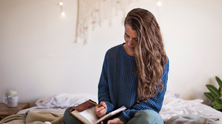 Woman journaling in bed