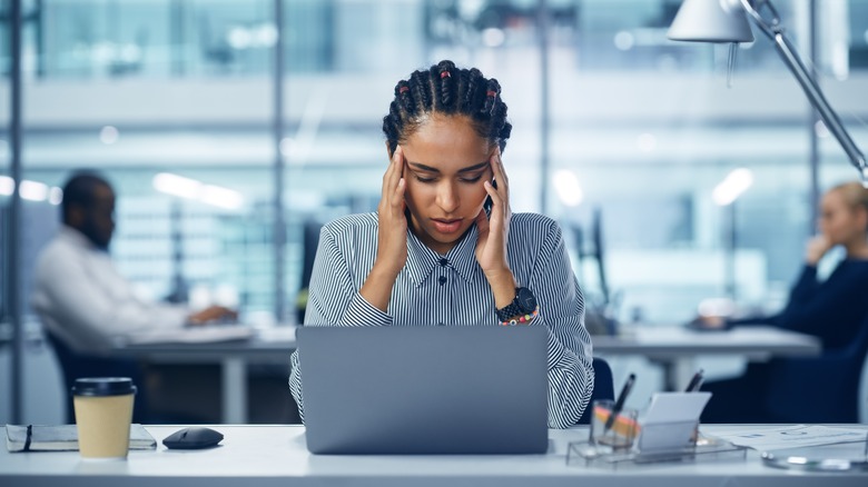 woman with headache near laptop