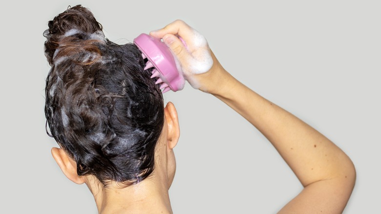 Woman using a scalp massager.