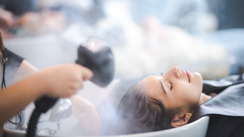 Woman getting a scalp steaming treatment.