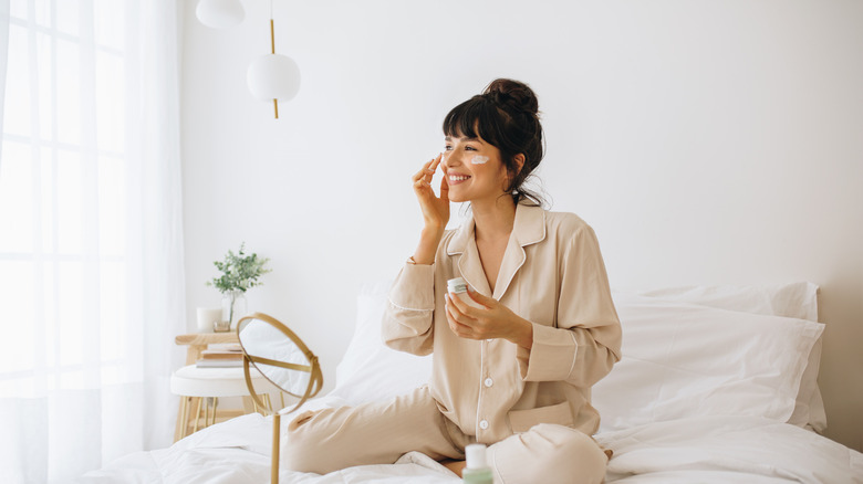 woman applying lotion to face