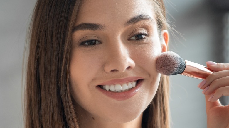 Woman using makeup brush