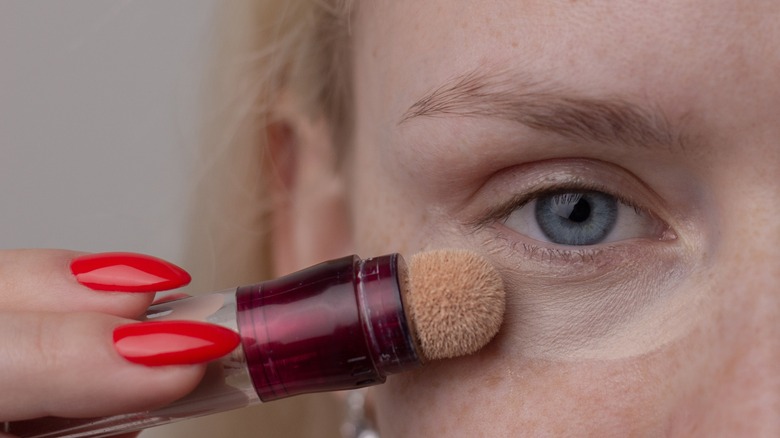 woman applying concealer