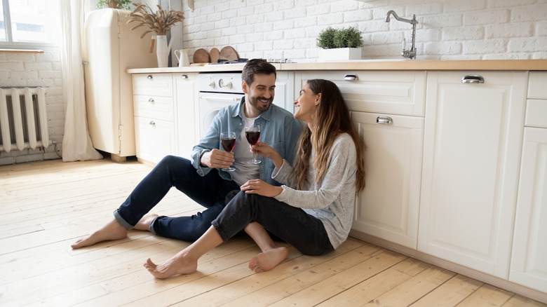 Couple discusses relationship over wine on kitchen floor