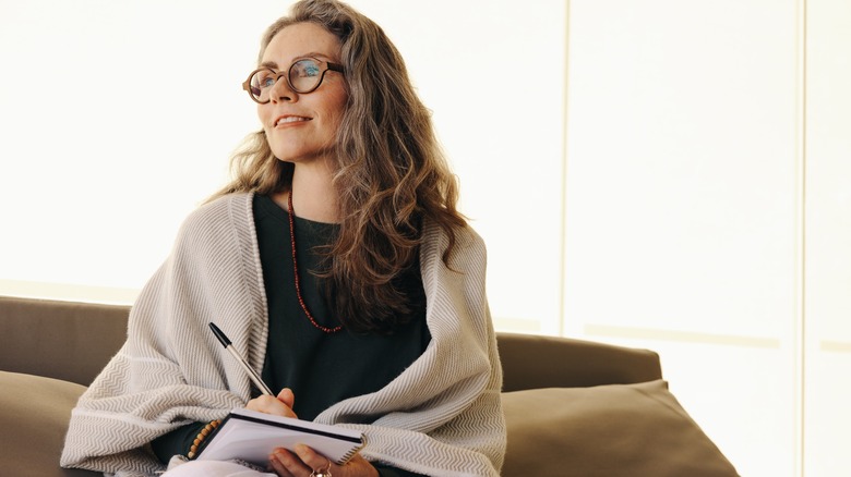 Woman writes intentions in journal 