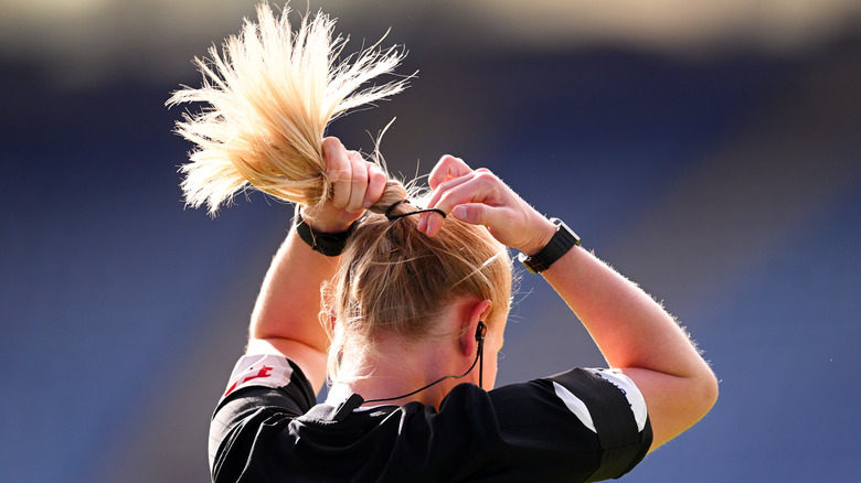 A woman tying her hair up