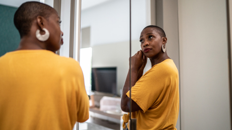 Woman admires self in mirror