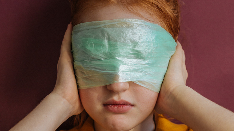 Girl with cling film on her face