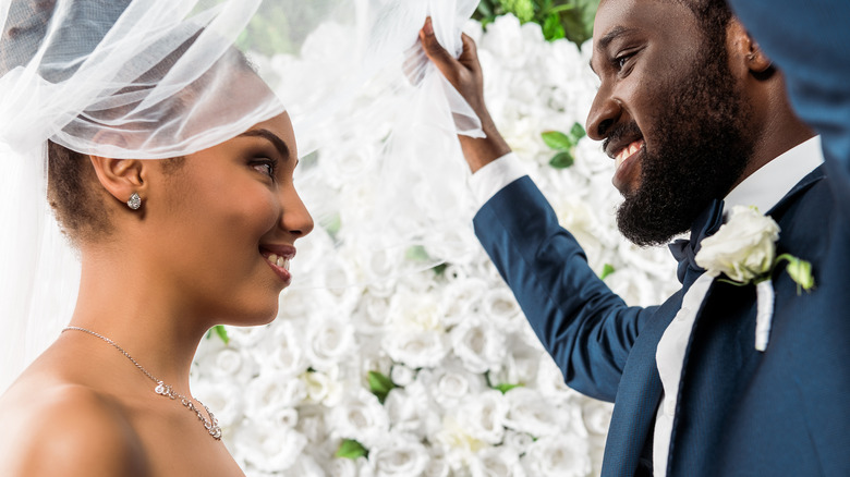 Groom lifting bride's veil