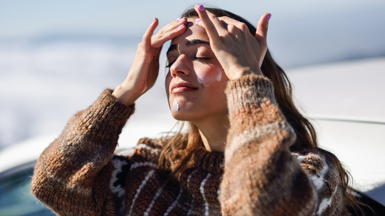 woman applying sunscreen to face 