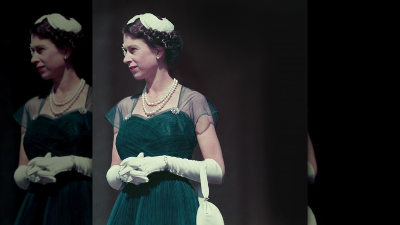 Queen Elizabeth wearing an emerald dress and pearls