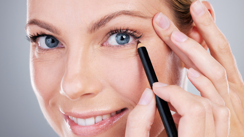 woman applying undereye eyeliner