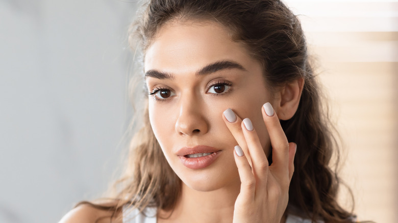 woman applying foundation on face 