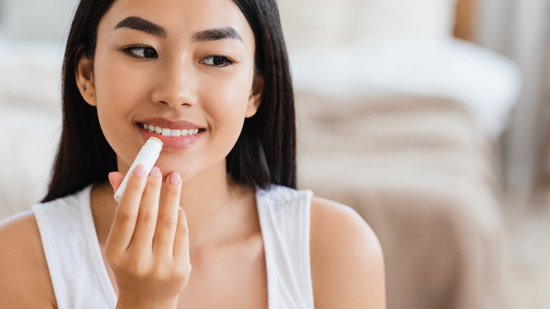 woman applying lip balm