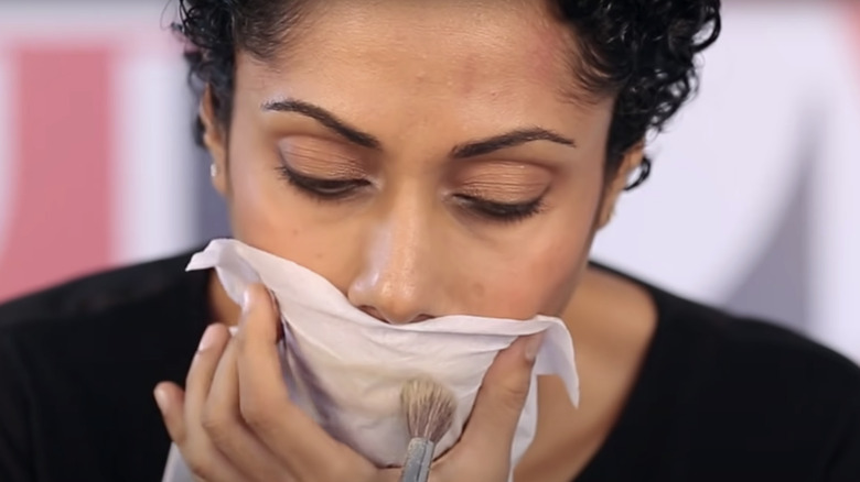 woman applying powder to lips