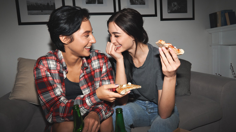 Couple laughing and eating pizza