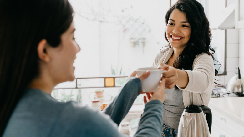 Woman handing coffee to her partner