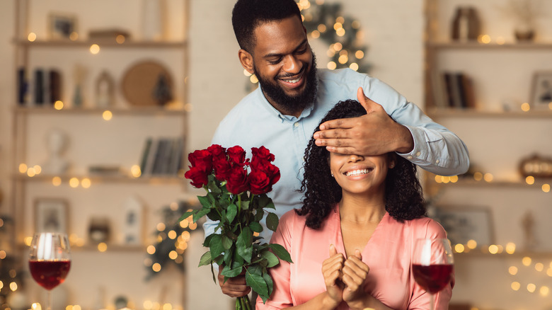 man surprising woman with roses