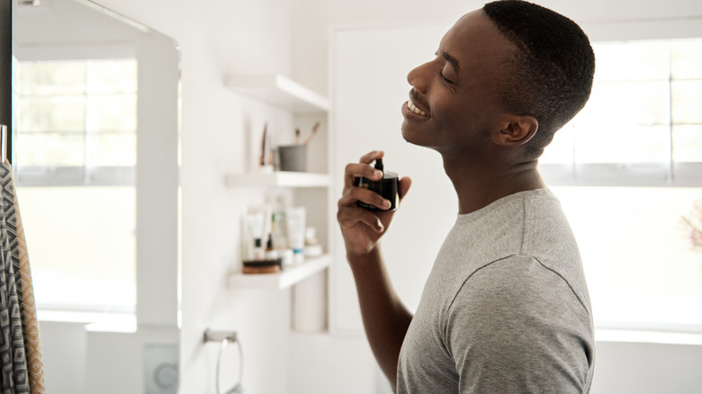 Man sprays neck with cologne 