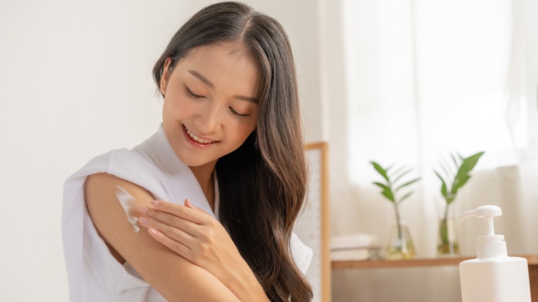 Woman applying moisturizer