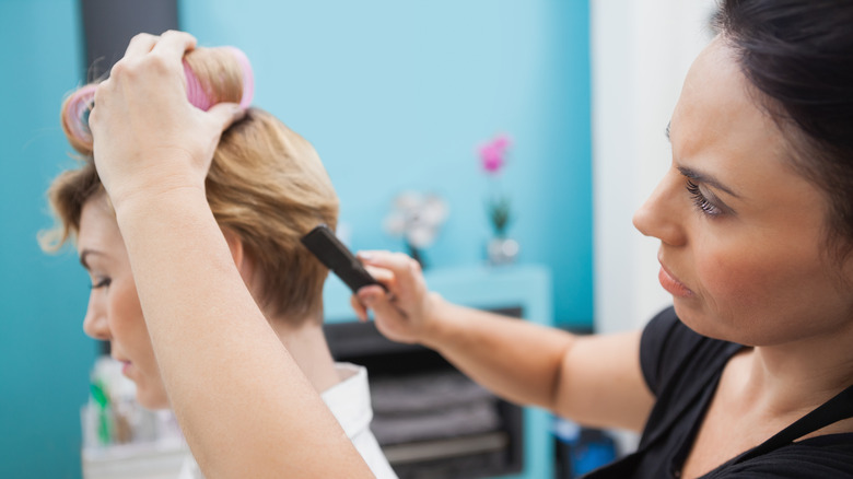 stylist putting short hair in rollers