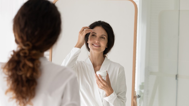 woman applying retinol night cream