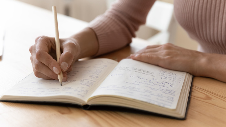 Woman writes in planner.