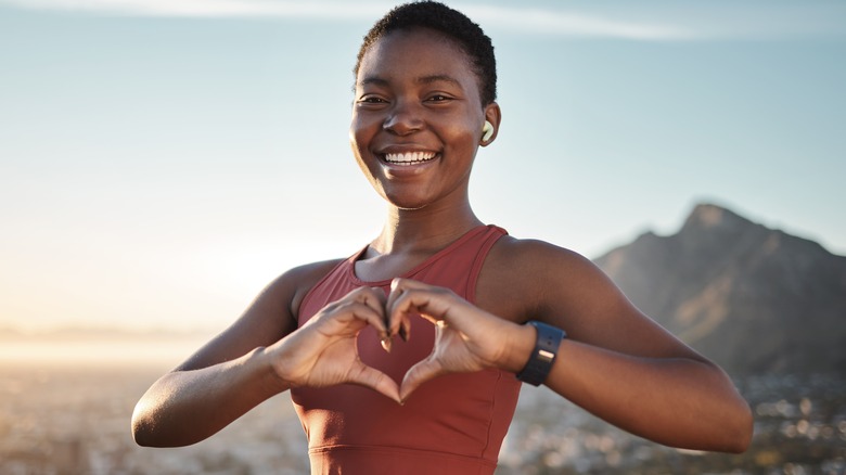 Smiling woman with hands forming heart