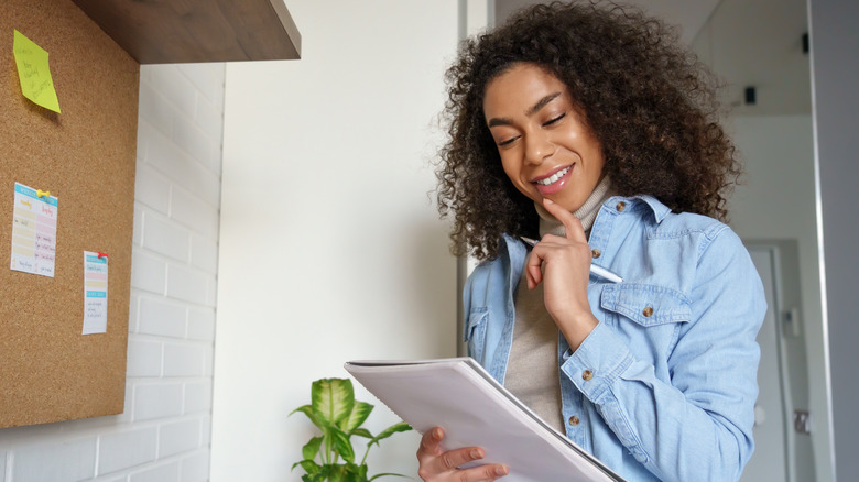 Woman writing list on notebook