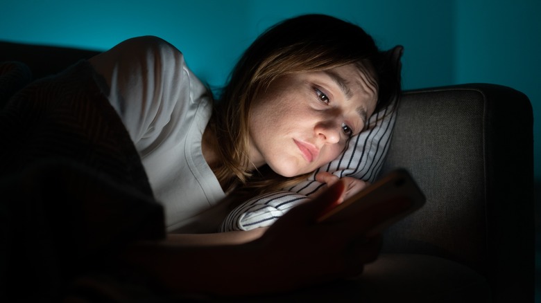 Woman looks sad at phone