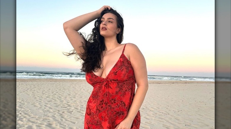 Woman posing in red sundress on the beach