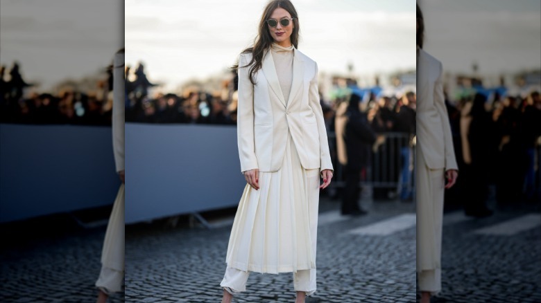 Karlie Kloss in white skirt suit and white pants