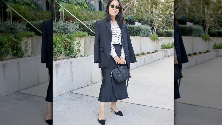 Woman in black skirt suit and striped shirt