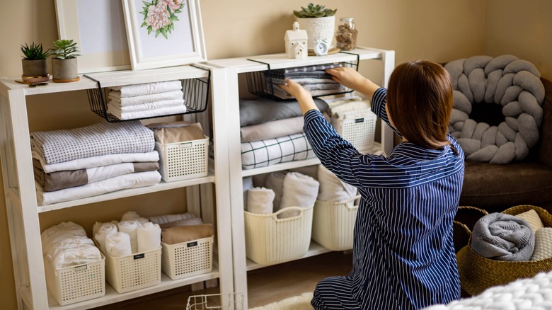 Woman organizing shelves in a room