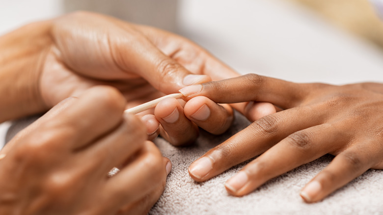 Woman having her nails cleaned