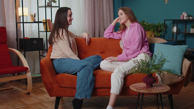 Lesbian couple talking on couch